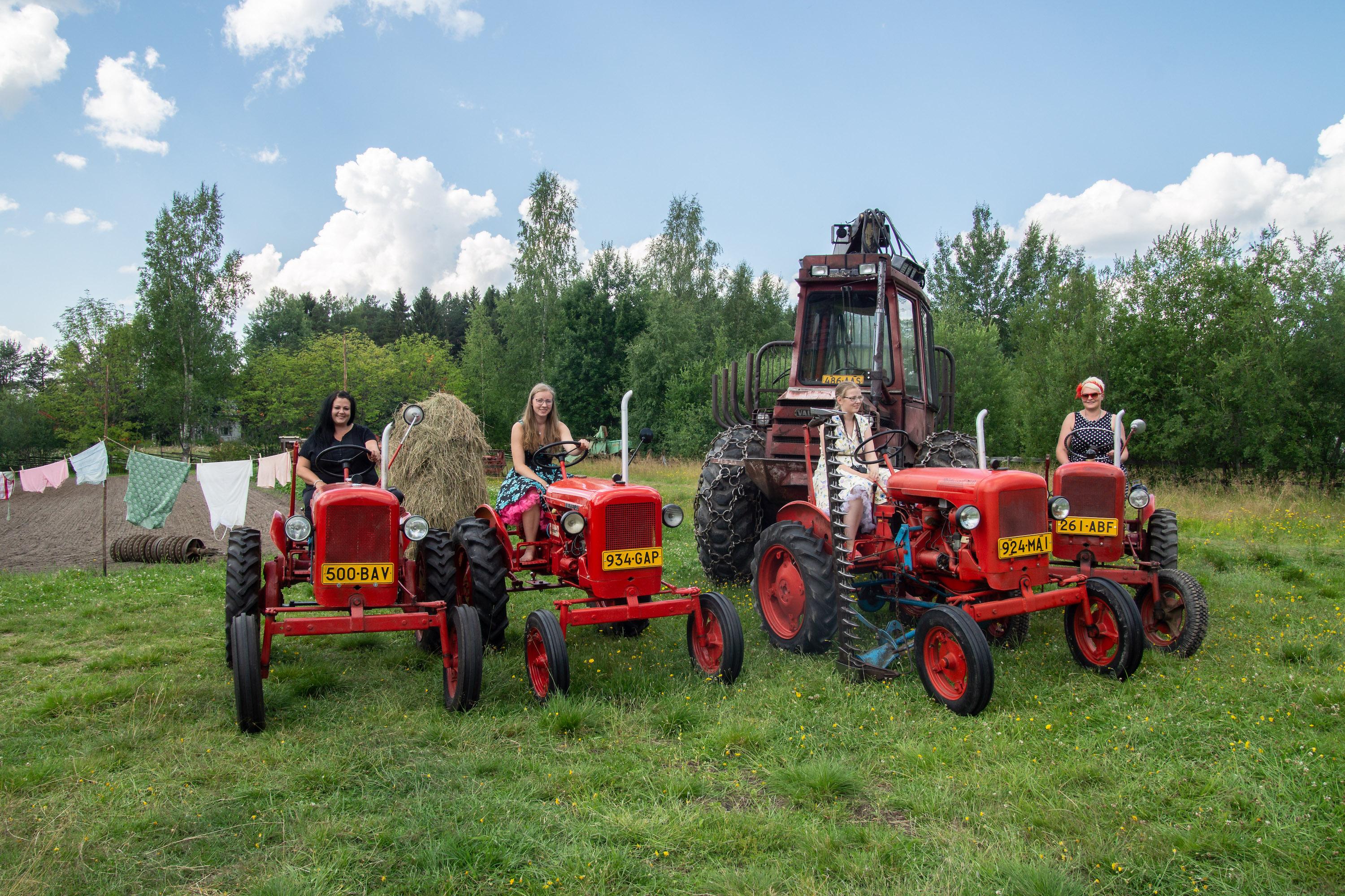 Valmet Martat Anne Ronkainen, Inka-Milla Kekki, Jenna-Janika Kekki ja Lilja Järvinen Valmet 20 -traktoreineen, taustalla Kekkien Valmet 872 -metsäkone